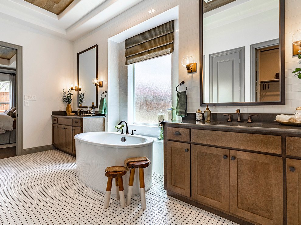 Design ideas for a classic ensuite bathroom in Dallas with shaker cabinets, medium wood cabinets, a freestanding bath, white tiles, white walls, a submerged sink, white floors and brown worktops.