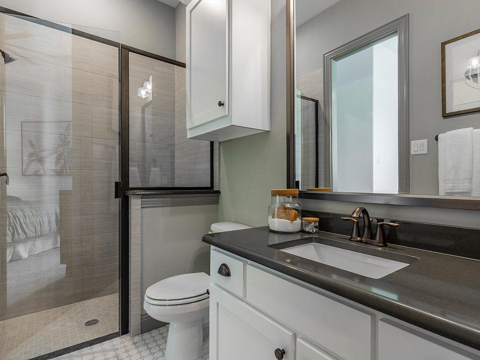 Cette photo montre une salle de bain chic avec un placard à porte shaker, des portes de placard blanches, WC séparés, un sol en carrelage de terre cuite, un lavabo encastré, un sol blanc, une cabine de douche à porte battante et un plan de toilette gris.