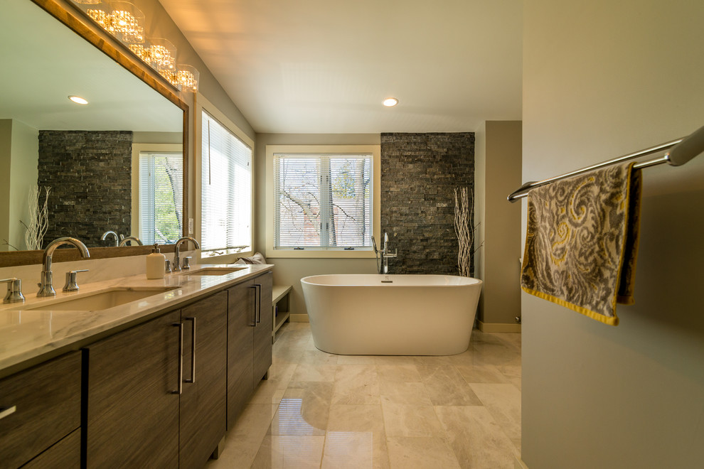 Aménagement d'une grande salle de bain principale contemporaine en bois foncé avec un placard à porte plane, une baignoire indépendante, des dalles de pierre, un mur vert, un sol en carrelage de porcelaine, un lavabo encastré et un plan de toilette en marbre.