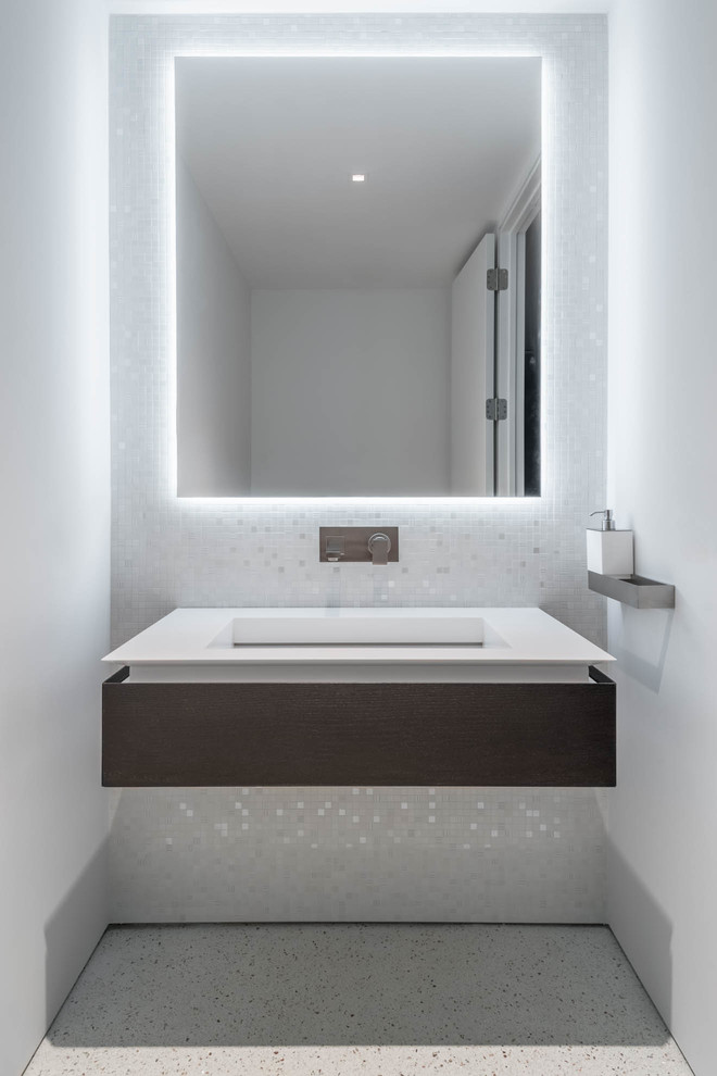 На фото: большая главная ванная комната в стиле модернизм с плоскими фасадами, белыми фасадами, отдельно стоящей ванной, открытым душем, унитазом-моноблоком, белой плиткой, белыми стенами, полом из керамической плитки, монолитной раковиной, столешницей из искусственного камня, белым полом и открытым душем с
