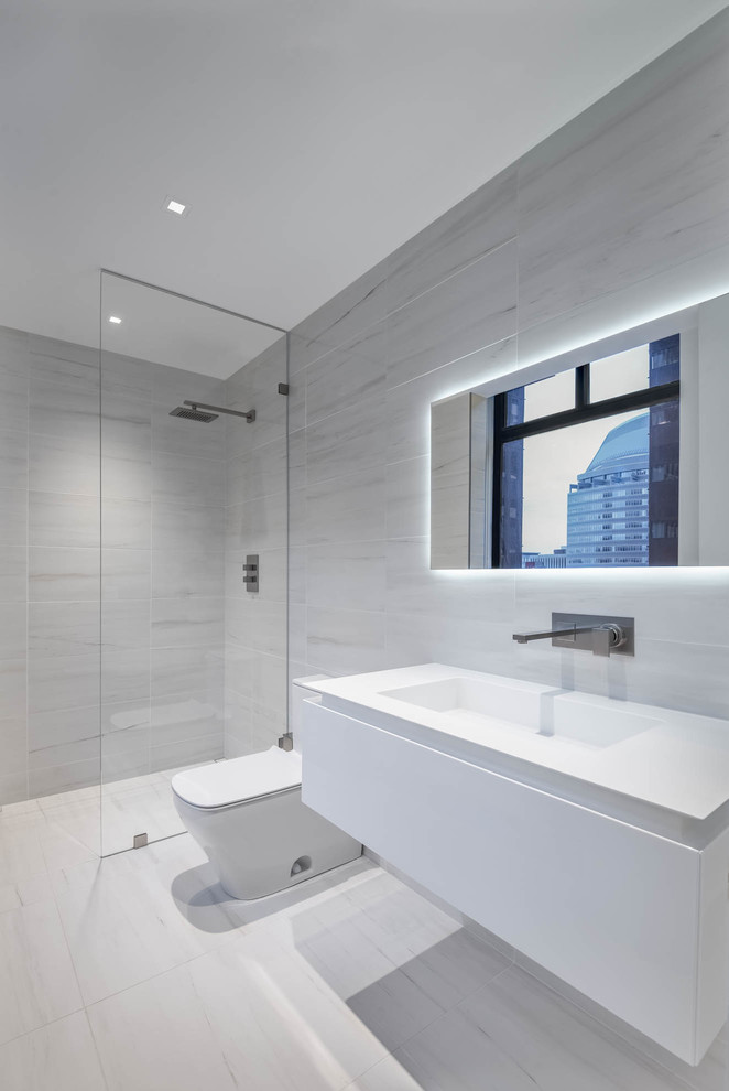 Inspiration for a large modern ensuite bathroom in Other with flat-panel cabinets, white cabinets, a freestanding bath, a walk-in shower, a one-piece toilet, white tiles, white walls, ceramic flooring, an integrated sink, solid surface worktops, white floors and an open shower.