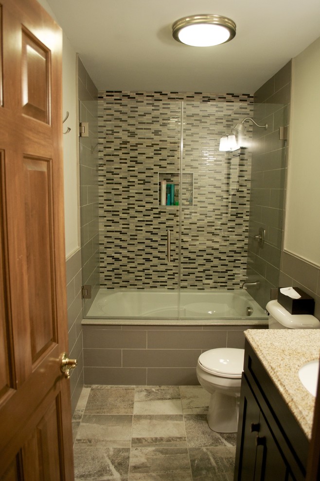 Cette image montre une petite salle de bain bohème en bois foncé avec un placard à porte shaker, une baignoire posée, WC séparés, un carrelage gris, des carreaux de porcelaine, un mur gris, un sol en carrelage de porcelaine, un lavabo encastré et un plan de toilette en granite.