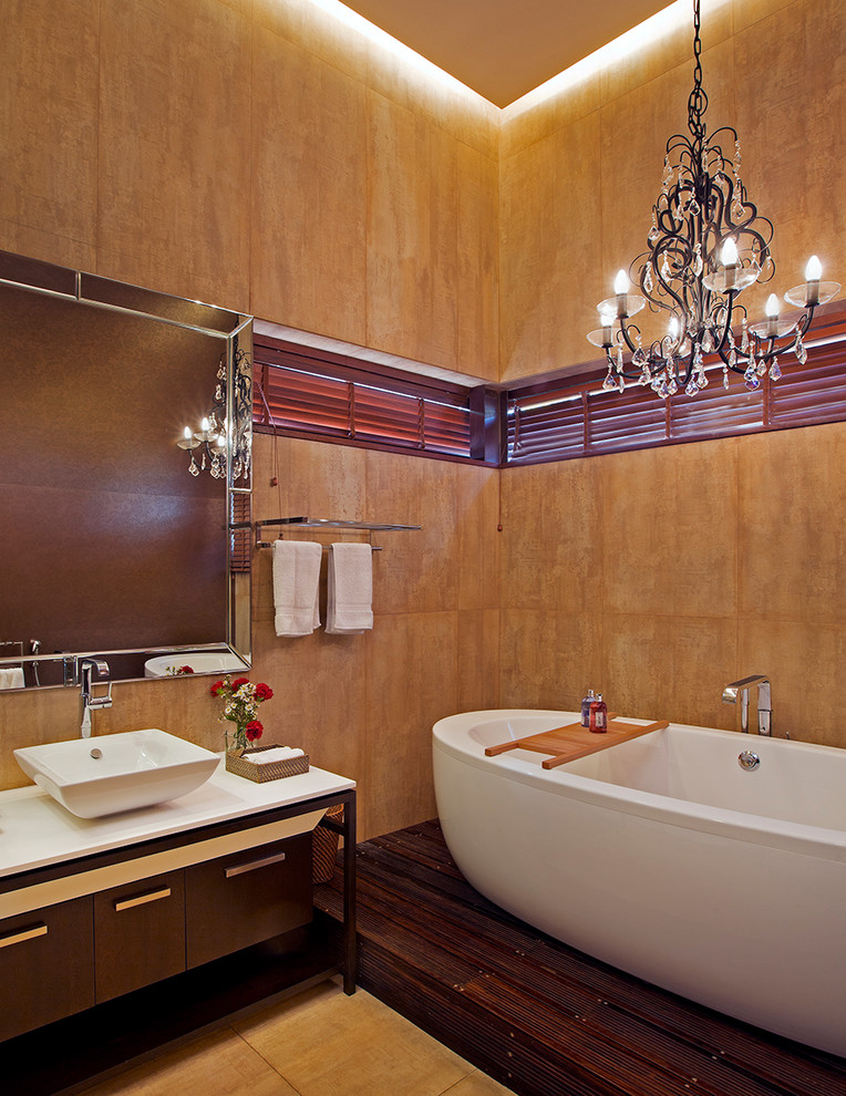 Badezimmer En Suite mit dunklen Holzschränken, freistehender Badewanne, oranger Wandfarbe, Aufsatzwaschbecken und flächenbündigen Schrankfronten in Bangalore