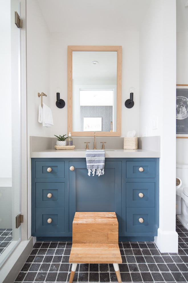 Design ideas for a beach style bathroom in Orange County with shaker cabinets, blue cabinets, an alcove shower, white walls, a submerged sink, black floors and grey worktops.