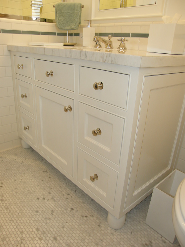 Foto på ett litet vintage badrum för barn, med luckor med profilerade fronter, vita skåp, vit kakel, keramikplattor, vita väggar, klinkergolv i keramik, ett undermonterad handfat och marmorbänkskiva