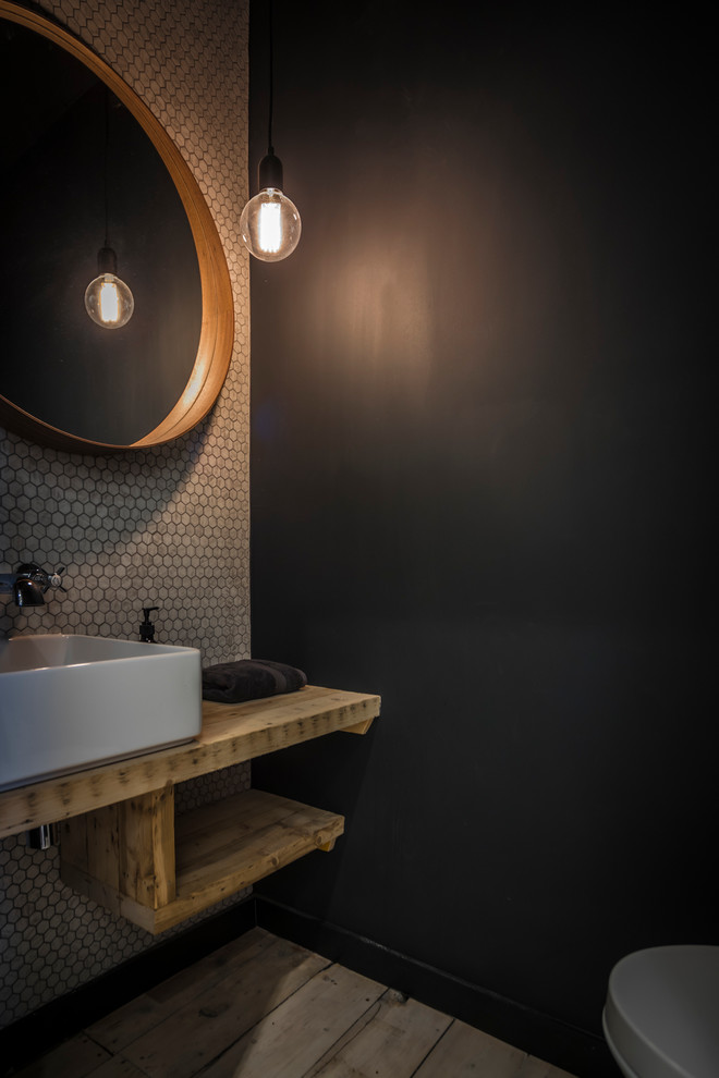 Bathroom - small contemporary light wood floor and gray floor bathroom idea in Edinburgh with black walls, a vessel sink and wood countertops