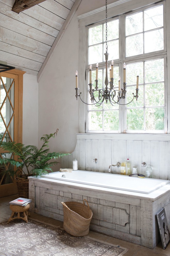 Cette image montre une grande salle de bain principale style shabby chic avec une baignoire posée et un mur blanc.