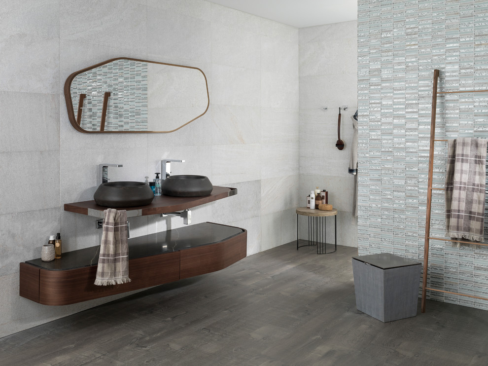 Doorless shower - mid-sized contemporary 3/4 gray tile and stone tile porcelain tile doorless shower idea in London with a vessel sink, dark wood cabinets, wood countertops and gray walls