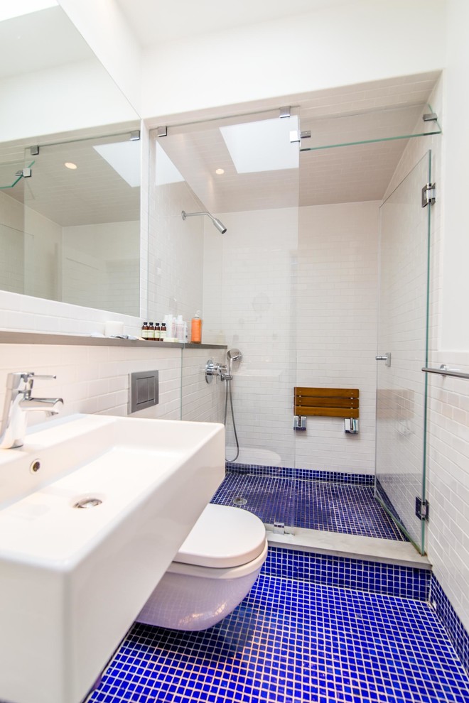 Immagine di una piccola sauna stile marino con lavabo sospeso, vasca ad alcova, WC sospeso, piastrelle blu, piastrelle in gres porcellanato, pareti bianche e pavimento in gres porcellanato