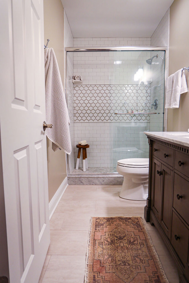Idéer för att renovera ett mellanstort vintage vit vitt badrum med dusch, med möbel-liknande, grå skåp, en toalettstol med separat cisternkåpa, vit kakel, keramikplattor, grå väggar, klinkergolv i porslin, ett undermonterad handfat, marmorbänkskiva, grått golv och dusch med skjutdörr
