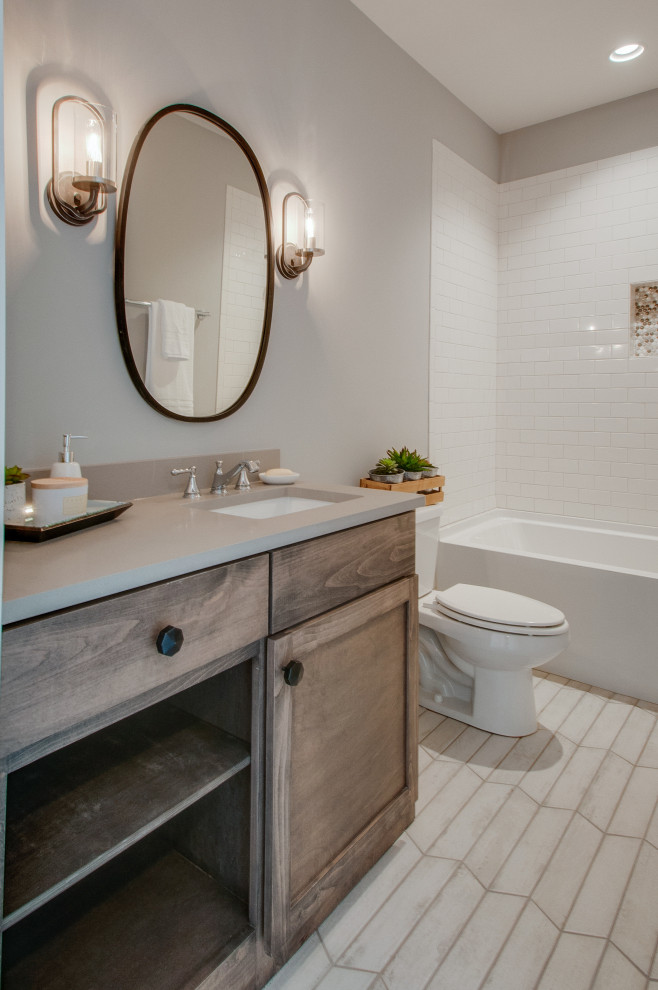 Medium sized classic family bathroom in Nashville with recessed-panel cabinets, medium wood cabinets, an alcove bath, an alcove shower, a two-piece toilet, white tiles, metro tiles, grey walls, porcelain flooring, a submerged sink, engineered stone worktops, grey floors and white worktops.