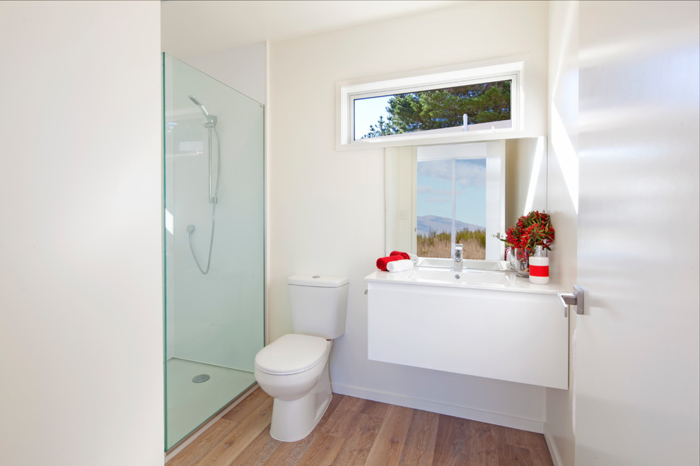 Kleines Modernes Badezimmer mit weißen Schränken, Laminat-Waschtisch, Toilette mit Aufsatzspülkasten und weißer Wandfarbe in Sonstige