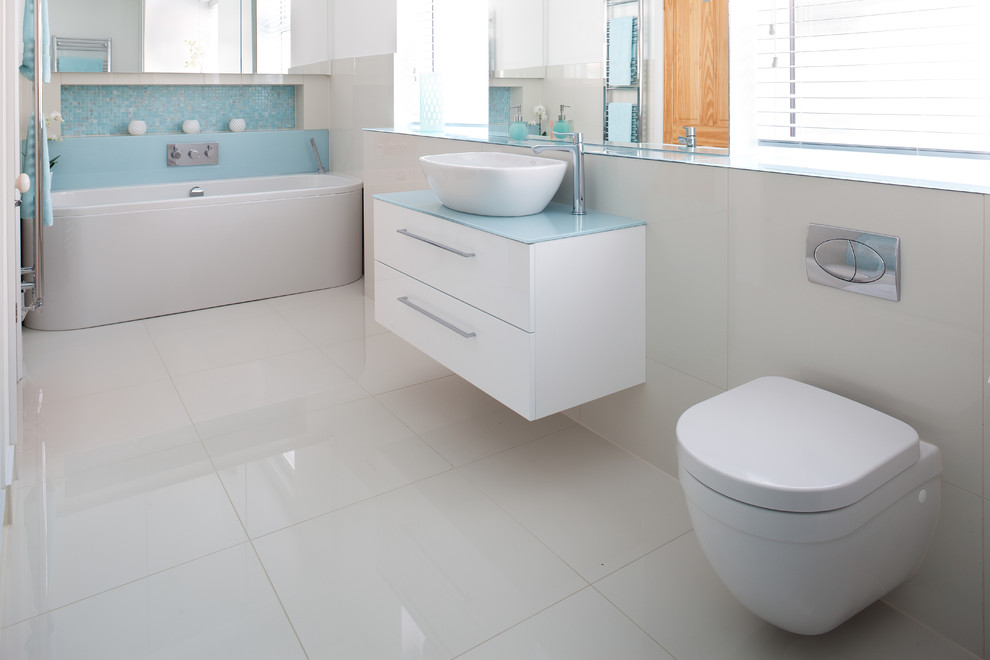 Пример оригинального дизайна: ванная комната среднего размера в современном стиле с консольной раковиной, стеклянной столешницей, отдельно стоящей ванной, инсталляцией, белой плиткой, керамогранитной плиткой и полом из керамогранита