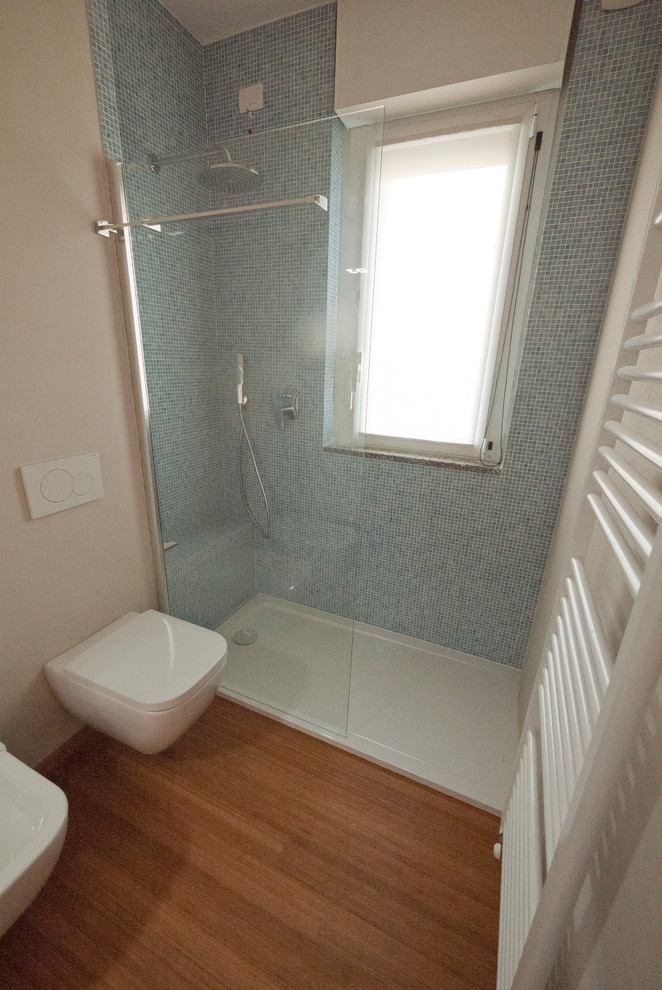Inspiration för mellanstora moderna en-suite badrum, med ett integrerad handfat, släta luckor, vita skåp, bänkskiva i kvarts, en öppen dusch, en vägghängd toalettstol, blå kakel, glaskakel, beige väggar och bambugolv