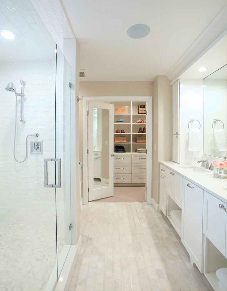 Example of a mid-sized trendy master white tile and ceramic tile white floor and mosaic tile floor alcove shower design in Other with shaker cabinets, white cabinets, an undermount sink, quartz countertops, a hinged shower door and beige walls