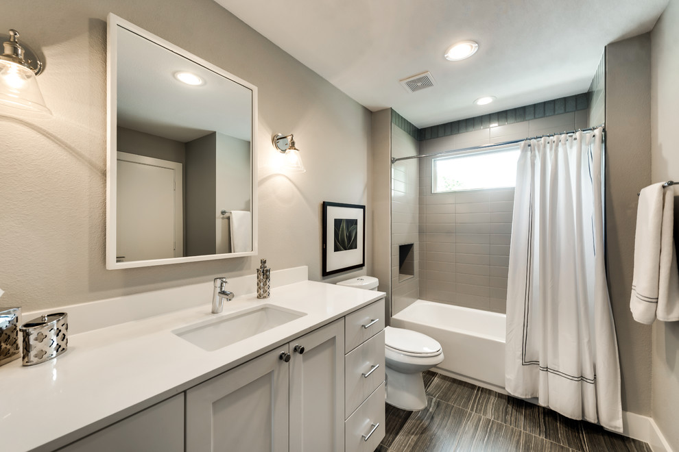 This is an example of a rural bathroom in Dallas with shaker cabinets, grey cabinets, an alcove bath, a shower/bath combination, a two-piece toilet, beige tiles, metro tiles, beige walls, porcelain flooring, a submerged sink, quartz worktops, multi-coloured floors and a shower curtain.