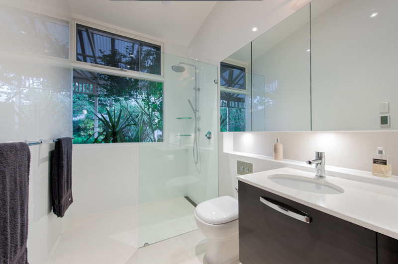 Esempio di una piccola stanza da bagno padronale moderna con lavabo sottopiano, doccia aperta, piastrelle bianche, pareti bianche, pavimento in gres porcellanato e ante in legno bruno