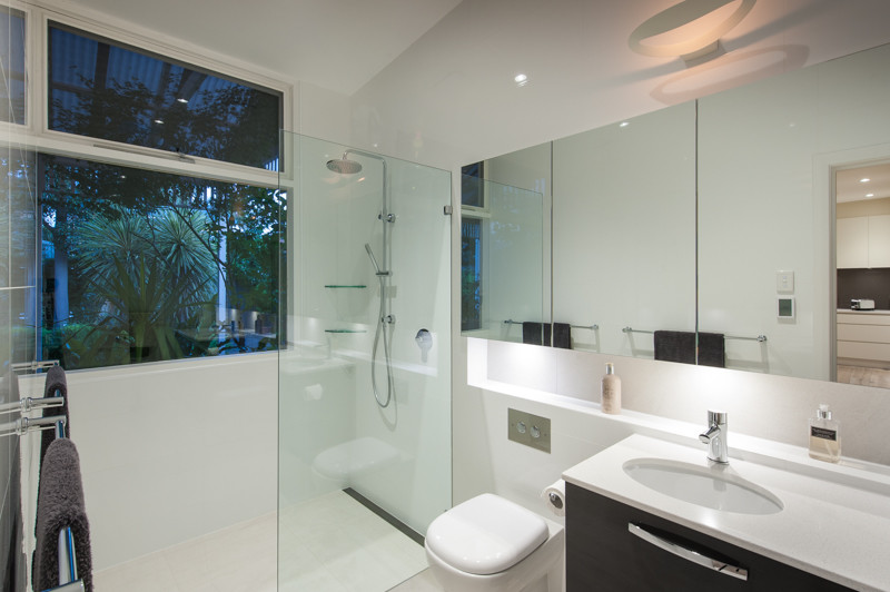 Esempio di una piccola stanza da bagno padronale minimalista con lavabo sottopiano, ante marroni, doccia aperta, piastrelle bianche, pareti bianche e pavimento in gres porcellanato