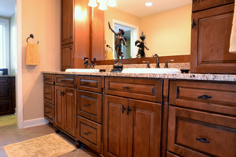 Inredning av ett klassiskt mellanstort en-suite badrum, med luckor med infälld panel, skåp i mellenmörkt trä, granitbänkskiva, en hörndusch, en toalettstol med hel cisternkåpa, beige kakel och beige väggar