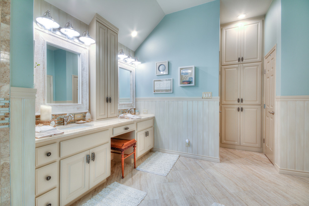 Идея дизайна: большая главная ванная комната в морском стиле с фасадами с выступающей филенкой, бежевыми фасадами, отдельно стоящей ванной, угловым душем, раздельным унитазом, бежевой плиткой, коричневой плиткой, каменной плиткой, синими стенами, врезной раковиной, бежевым полом, открытым душем и бежевой столешницей