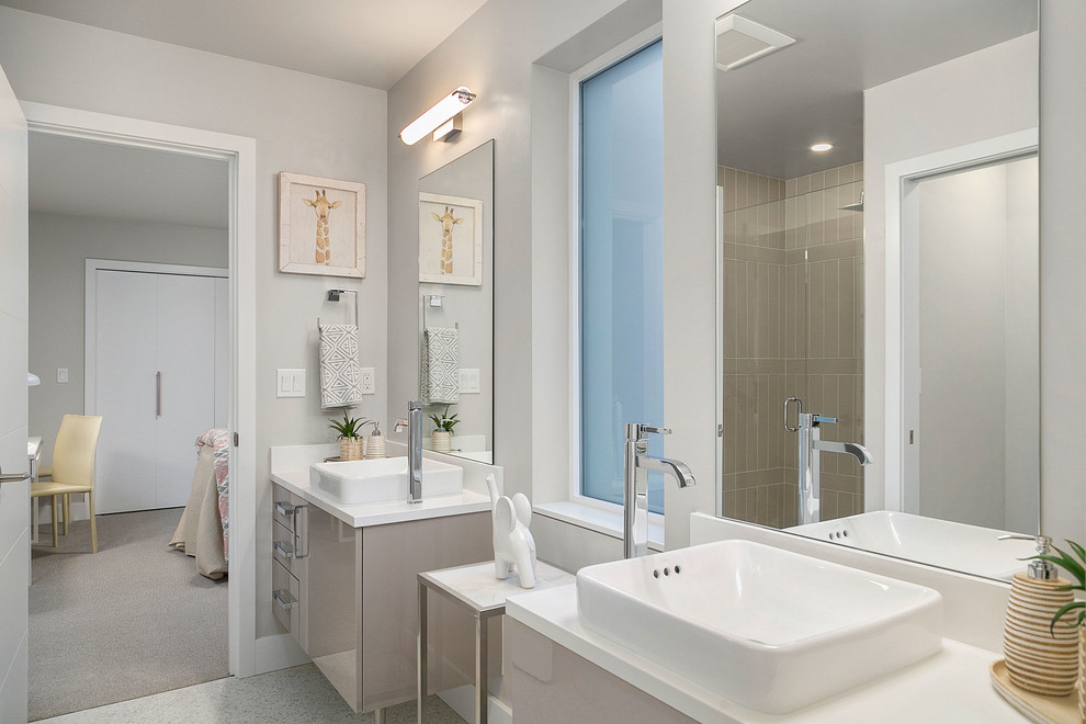 Imagen de cuarto de baño infantil actual con armarios con paneles lisos, puertas de armario grises, paredes grises, lavabo sobreencimera y encimeras blancas