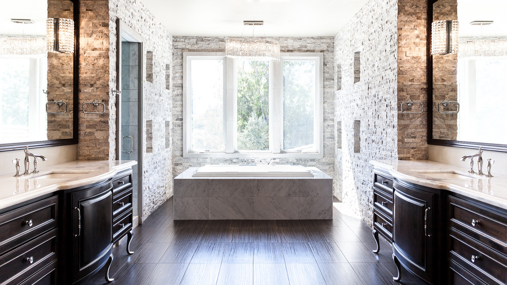 Drop-in bathtub - mediterranean gray tile and stone tile porcelain tile drop-in bathtub idea in Sacramento with an undermount sink, furniture-like cabinets, dark wood cabinets and white walls