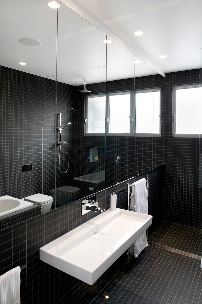 Contemporary bathroom in Sydney with a wall-mounted sink, black tiles, mosaic tiles and mosaic tile flooring.