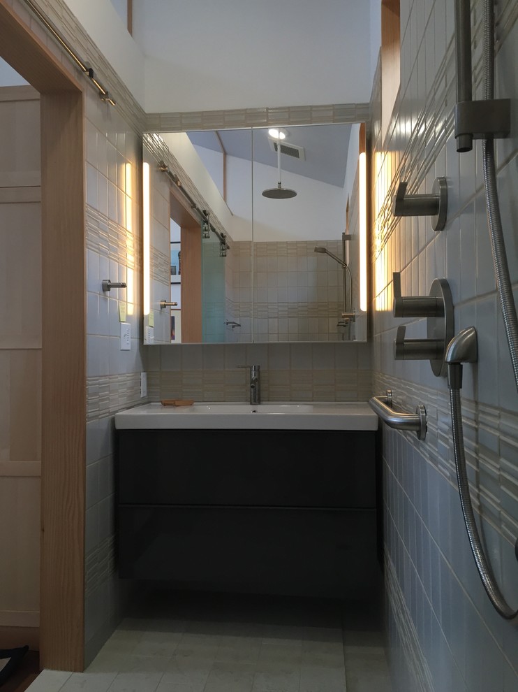 Modern inredning av ett litet badrum, med ett integrerad handfat, släta luckor, skåp i mörkt trä, bänkskiva i akrylsten, en öppen dusch, en vägghängd toalettstol, beige kakel, porslinskakel, beige väggar och klinkergolv i keramik
