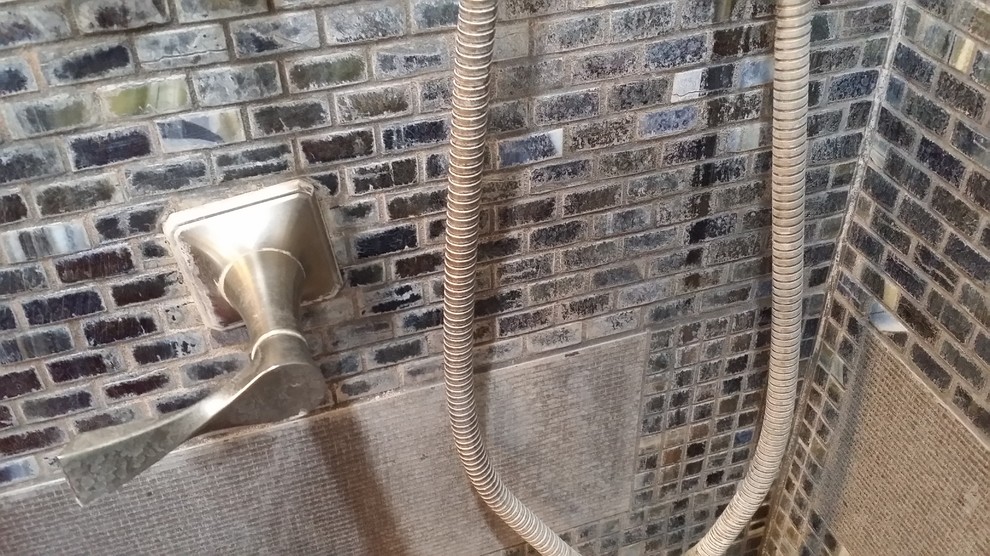 Immagine di una stanza da bagno padronale minimal di medie dimensioni con doccia ad angolo, piastrelle di vetro e pavimento con piastrelle di ciottoli
