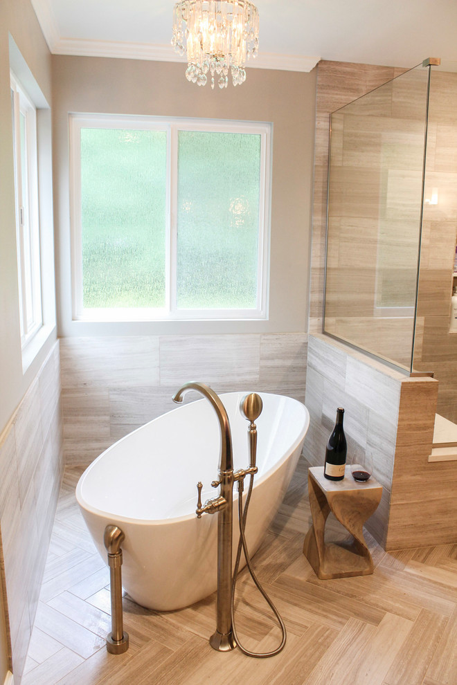 Klassisk inredning av ett stort en-suite badrum, med bruna skåp, ett fristående badkar, kakelplattor, kalkstensgolv, bänkskiva i kvarts, dusch med gångjärnsdörr, skåp i shakerstil, en dusch i en alkov, grå väggar, ett undermonterad handfat och beiget golv