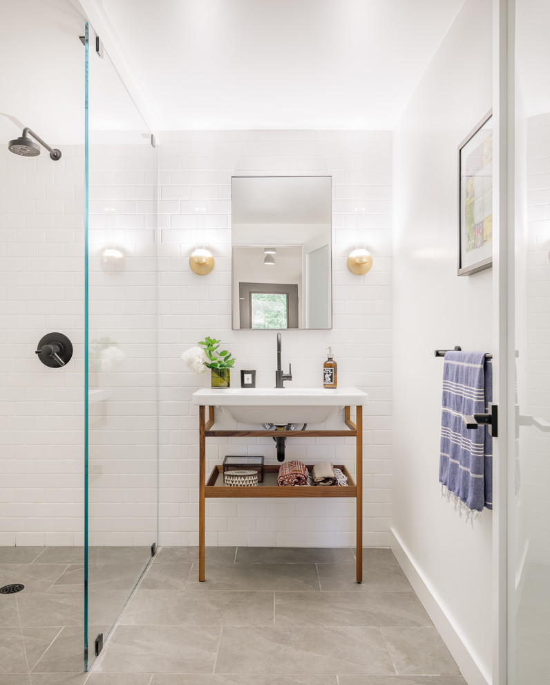 Modern inredning av ett mellanstort badrum med dusch, med vit kakel, tunnelbanekakel, vita väggar, skiffergolv, grått golv, med dusch som är öppen, öppna hyllor, skåp i mellenmörkt trä, våtrum och ett konsol handfat