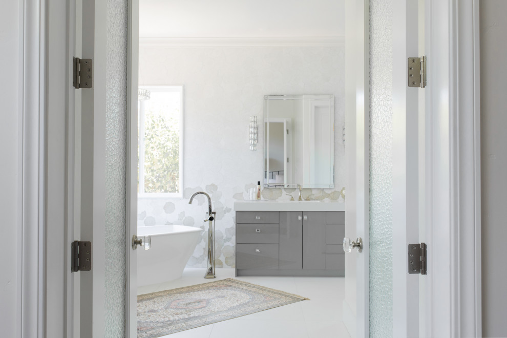 На фото: большая главная ванная комната в стиле неоклассика (современная классика) с серыми фасадами, открытым душем, открытым душем, белой столешницей, сиденьем для душа и тумбой под две раковины