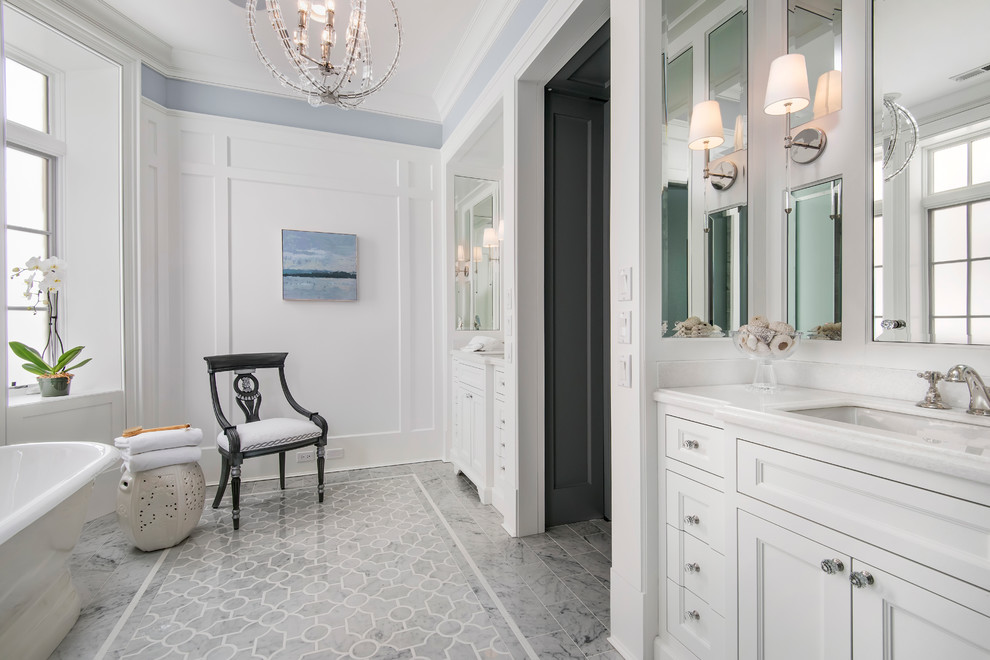 Пример оригинального дизайна: большая главная ванная комната в классическом стиле с фасадами с утопленной филенкой, белыми фасадами, отдельно стоящей ванной, серой плиткой, врезной раковиной, раздельным унитазом, каменной плиткой, белыми стенами и полом из керамогранита