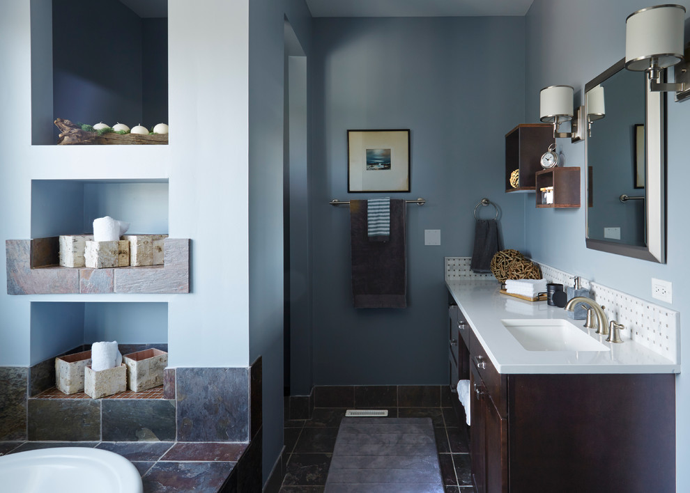 シカゴにある高級な中くらいなトランジショナルスタイルのおしゃれなマスターバスルーム (シェーカースタイル扉のキャビネット、濃色木目調キャビネット、ドロップイン型浴槽、アルコーブ型シャワー、マルチカラーのタイル、石タイル、青い壁、一体型トイレ	、スレートの床、珪岩の洗面台、茶色い床) の写真