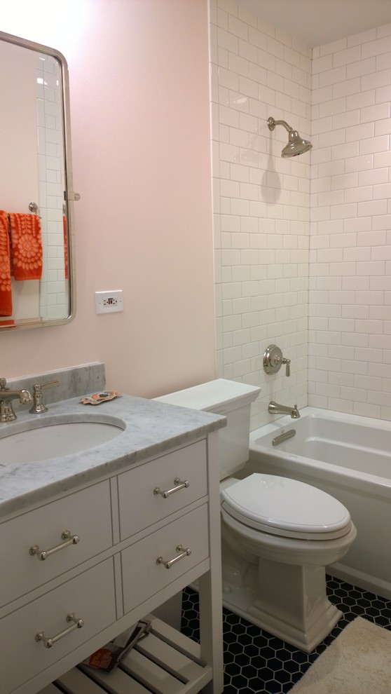 シカゴにある高級な小さなトラディショナルスタイルのおしゃれな子供用バスルーム (アンダーカウンター洗面器、家具調キャビネット、白いキャビネット、珪岩の洗面台、アルコーブ型浴槽、シャワー付き浴槽	、分離型トイレ、白いタイル、セラミックタイル、ピンクの壁、磁器タイルの床) の写真