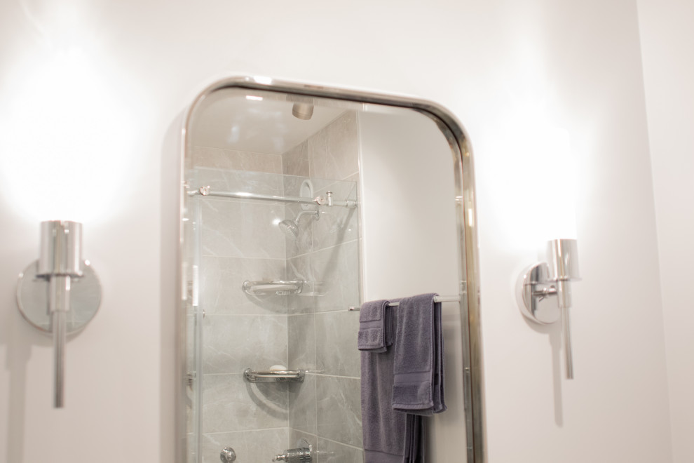 Modelo de cuarto de baño principal y único moderno con puertas de armario azules, lavabo encastrado, ducha con puerta corredera, encimeras blancas y banco de ducha