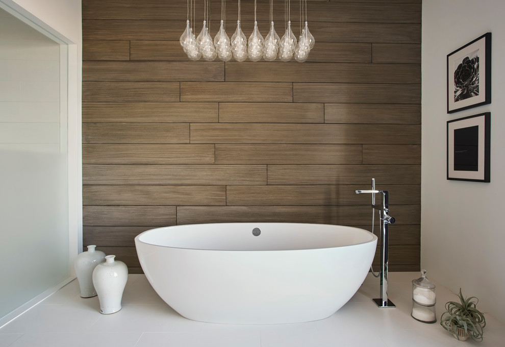 Photo of a medium sized modern ensuite bathroom with flat-panel cabinets, dark wood cabinets, a freestanding bath, beige walls, ceramic flooring, an integrated sink, solid surface worktops, brown tiles, porcelain tiles and white floors.