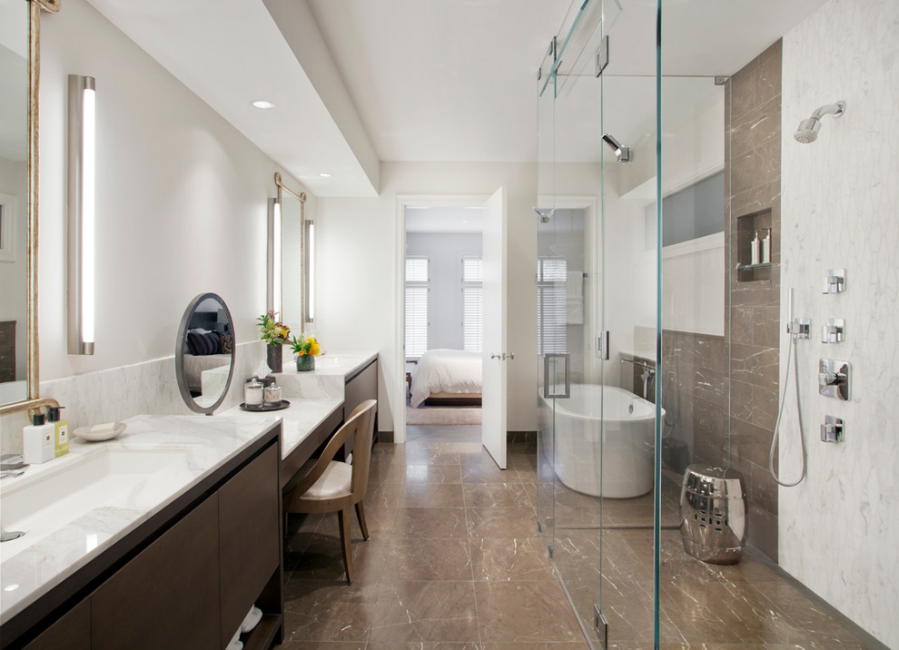 Modern inredning av ett stort vit vitt en-suite badrum, med ett avlångt handfat, släta luckor, skåp i mörkt trä, ett fristående badkar, en hörndusch, brun kakel, vita väggar och brunt golv