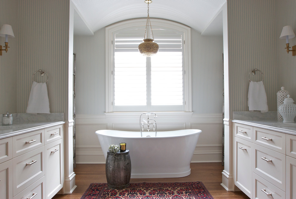 Imagen de cuarto de baño clásico renovado con puertas de armario blancas y bañera exenta