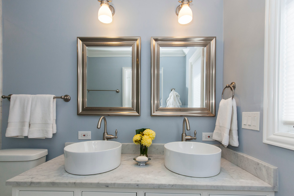 Klassisk inredning av ett mellanstort en-suite badrum, med ett fristående handfat, luckor med profilerade fronter, vita skåp, marmorbänkskiva, en hörndusch, en toalettstol med separat cisternkåpa, grå kakel, tunnelbanekakel, grå väggar och mosaikgolv