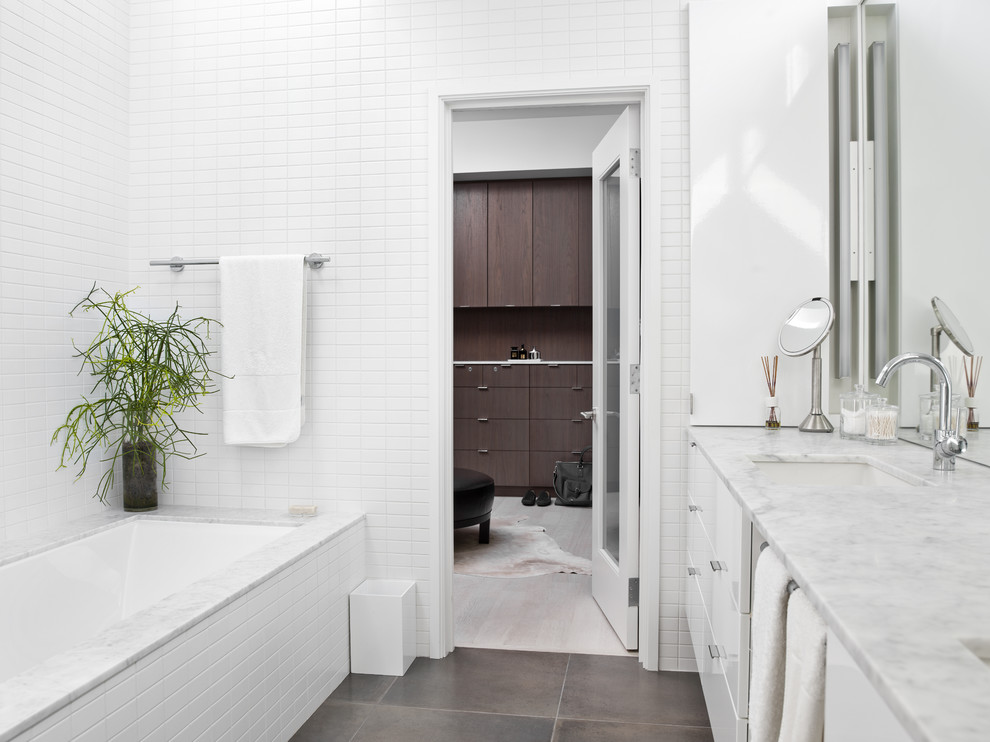 Стильный дизайн: главная ванная комната среднего размера в современном стиле с плоскими фасадами, белыми фасадами, полновстраиваемой ванной, унитазом-моноблоком, белой плиткой, керамической плиткой, белыми стенами, полом из керамогранита, врезной раковиной и мраморной столешницей - последний тренд