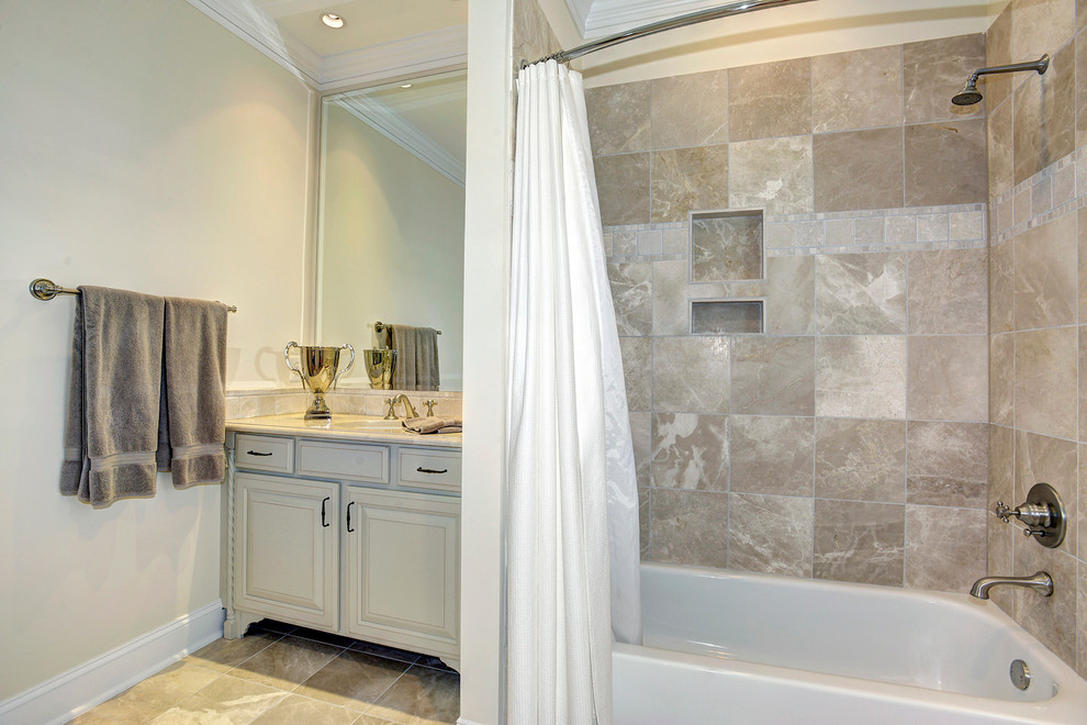 Inspiration for a timeless beige tile and marble tile marble floor tub/shower combo remodel in DC Metro with raised-panel cabinets, light wood cabinets, beige walls, an undermount sink, marble countertops and beige countertops