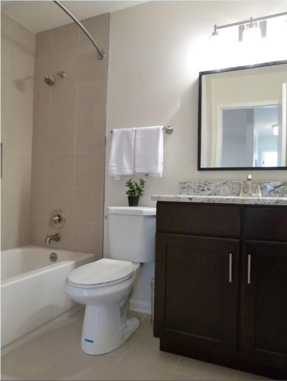 Idéer för ett mellanstort klassiskt badrum, med ett undermonterad handfat, luckor med infälld panel, skåp i mörkt trä, granitbänkskiva, ett badkar i en alkov, en dusch i en alkov, en toalettstol med separat cisternkåpa, beige kakel, porslinskakel, grå väggar och klinkergolv i porslin
