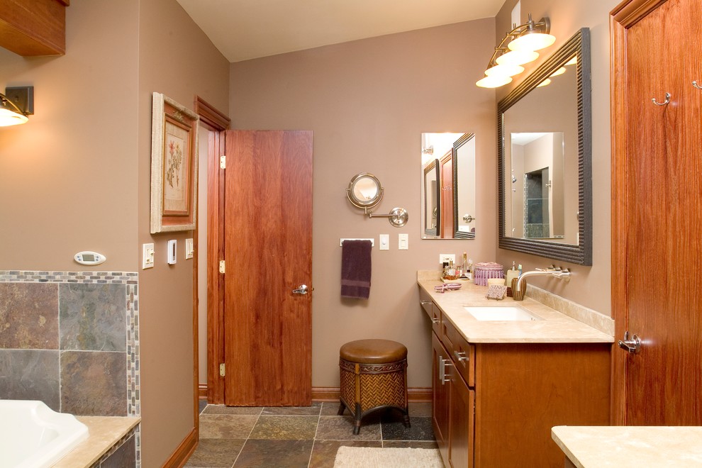Exempel på ett stort modernt badrum, med ett undermonterad handfat, släta luckor, skåp i mellenmörkt trä, bänkskiva i kalksten, ett platsbyggt badkar, en dusch i en alkov, en toalettstol med hel cisternkåpa, svart kakel, stenkakel och skiffergolv