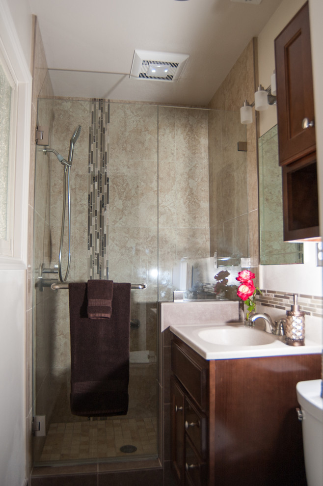 This is an example of a medium sized classic ensuite bathroom in San Diego with recessed-panel cabinets, dark wood cabinets, an alcove shower, a two-piece toilet, beige tiles, glass tiles, white walls, travertine flooring, an integrated sink, onyx worktops, a hinged door, white worktops, a single sink and a built in vanity unit.