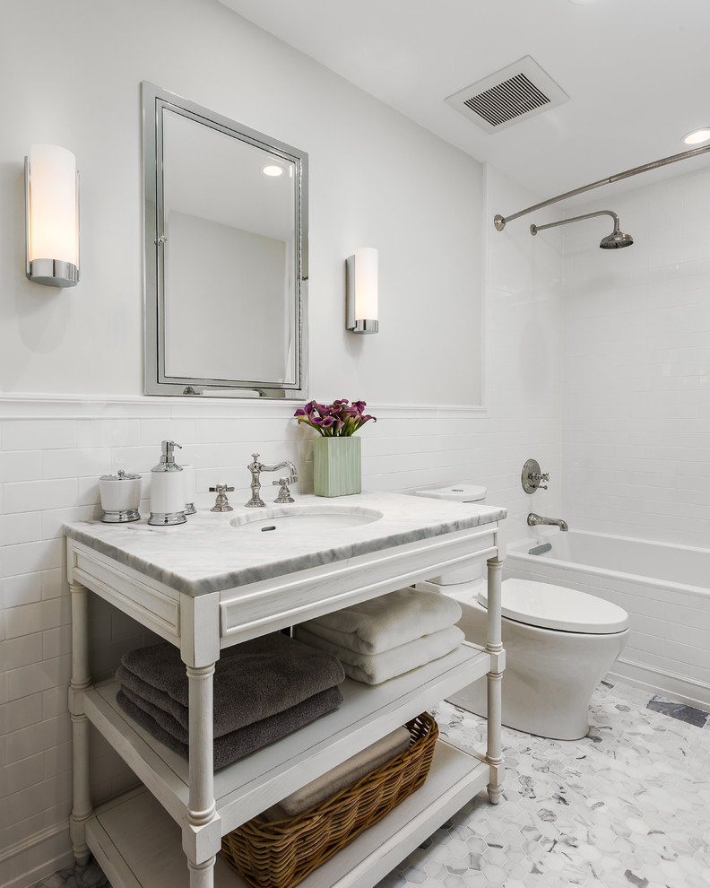 На фото: ванная комната в стиле неоклассика (современная классика) с консольной раковиной, открытыми фасадами, белыми фасадами, ванной в нише, душем над ванной, раздельным унитазом и белой плиткой с