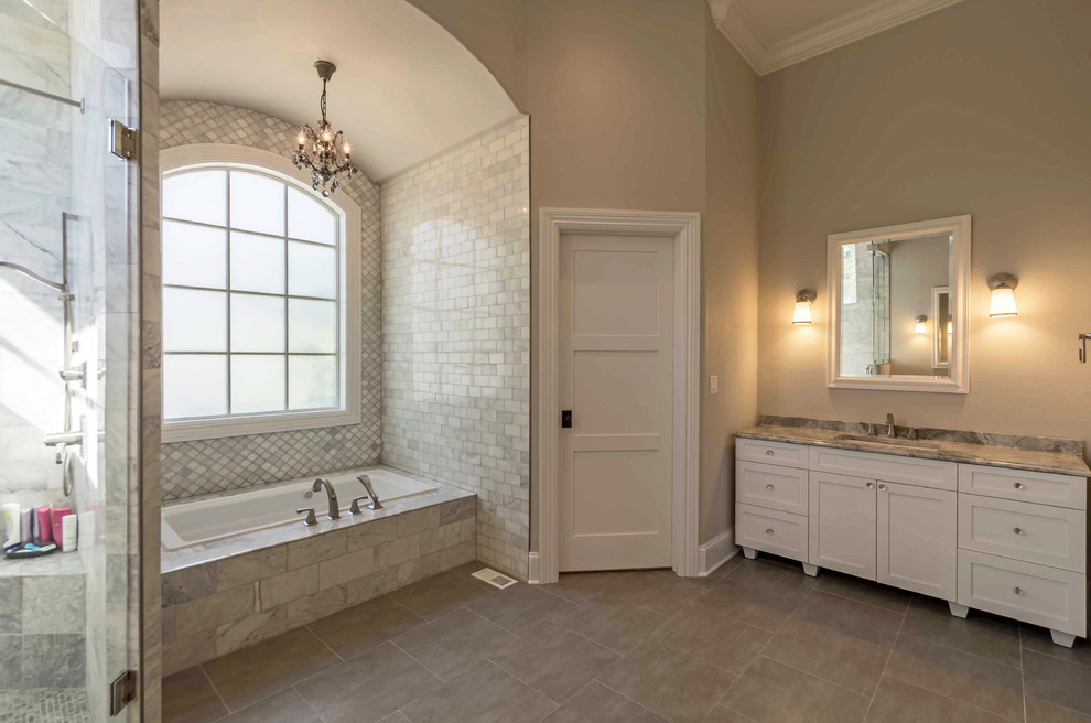 На фото: большая главная ванная комната в стиле неоклассика (современная классика) с фасадами с утопленной филенкой, белыми фасадами, полновстраиваемой ванной, угловым душем, унитазом-моноблоком, черно-белой плиткой, серой плиткой, разноцветной плиткой, плиткой кабанчик, бежевыми стенами, полом из керамогранита, врезной раковиной, мраморной столешницей, коричневым полом, душем с распашными дверями, бежевой столешницей, тумбой под одну раковину, встроенной тумбой, кессонным потолком и обоями на стенах с