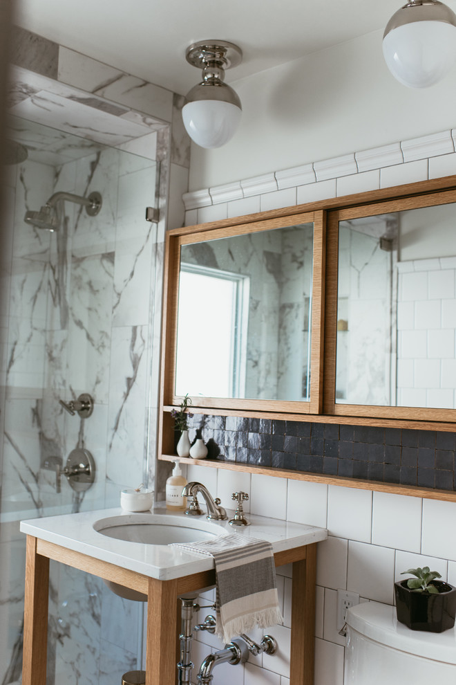Idéer för att renovera ett mellanstort eklektiskt vit vitt badrum med dusch, med öppna hyllor, en hörndusch, svart och vit kakel, keramikplattor, vita väggar, mosaikgolv, ett nedsänkt handfat, blått golv och dusch med gångjärnsdörr