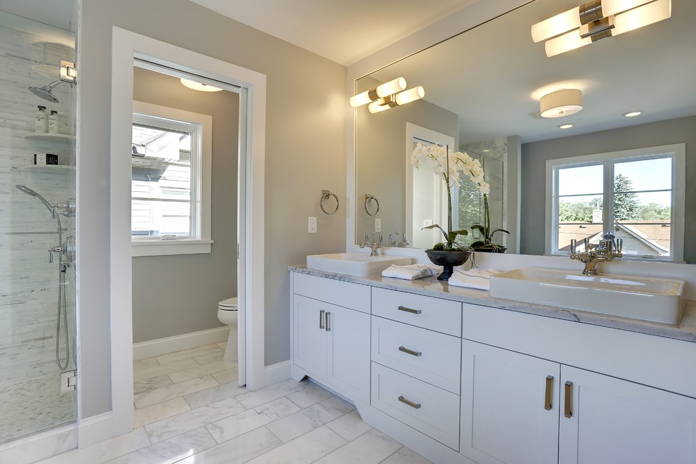 Large transitional master gray tile, white tile and matchstick tile marble floor and gray floor bathroom photo in Minneapolis with shaker cabinets, white cabinets, a two-piece toilet, gray walls, a vessel sink, marble countertops and a hinged shower door