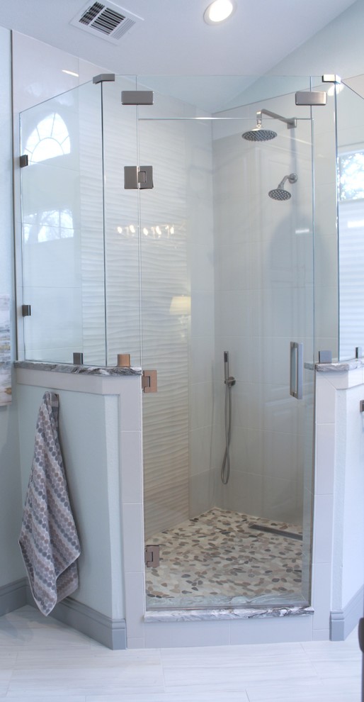 Идея дизайна: большая главная ванная комната в стиле неоклассика (современная классика) с фасадами островного типа, серыми фасадами, полновстраиваемой ванной, угловым душем, раздельным унитазом, бежевой плиткой, керамогранитной плиткой, серыми стенами, полом из керамической плитки, врезной раковиной, столешницей из гранита, душем с распашными дверями и разноцветной столешницей